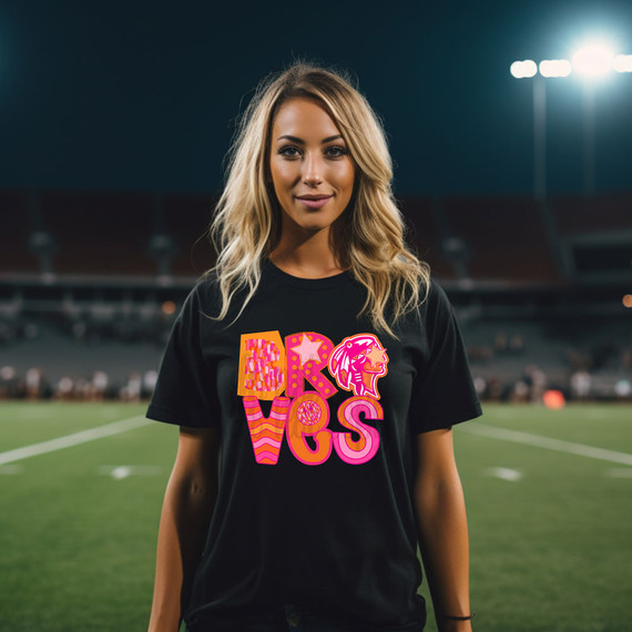 Braves Pink/Orange Block DTF Heat Transfer, a colorful and vibrant design with the word 'BRAVES' on a woman's black t-shirt at a sports stadium.
