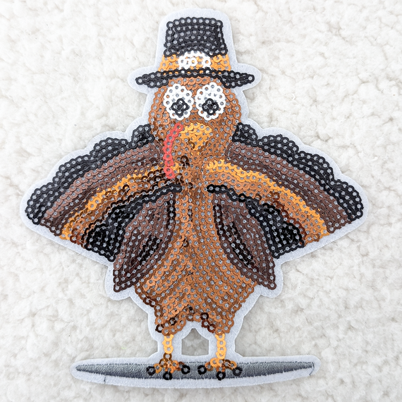 Turkey Sequin HAT/POCKET Patch, colorful embroidered patch featuring a turkey wearing a black hat and holding a red straw, decorated with shiny sequins.