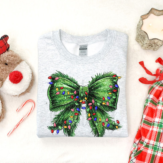 Mean Guy Christmas Light Bow DTF Heat Transfer, a grey t-shirt with a large green Christmas bow design decorated with colorful lights.
