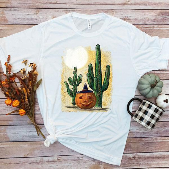 Jack O'Lantern Cactus Sublimation Transfer, Halloween-themed design featuring a jack-o'-lantern with a witch hat and multiple cacti on a t-shirt.