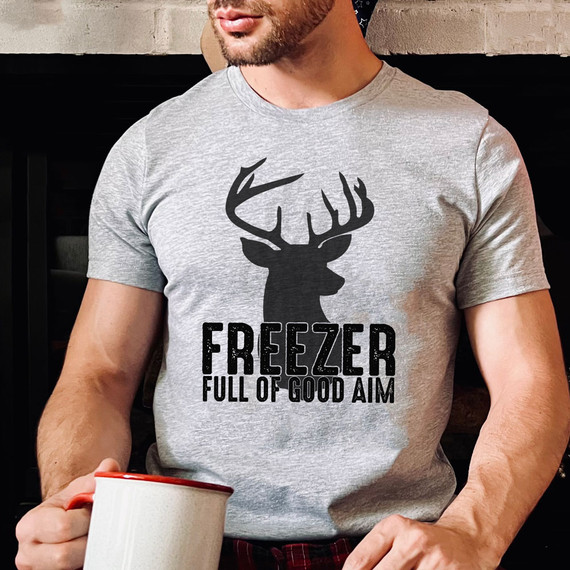 Freezer Full Of Good Aim DTF Heat Transfer, printed on a gray t-shirt worn by a man holding a mug.
