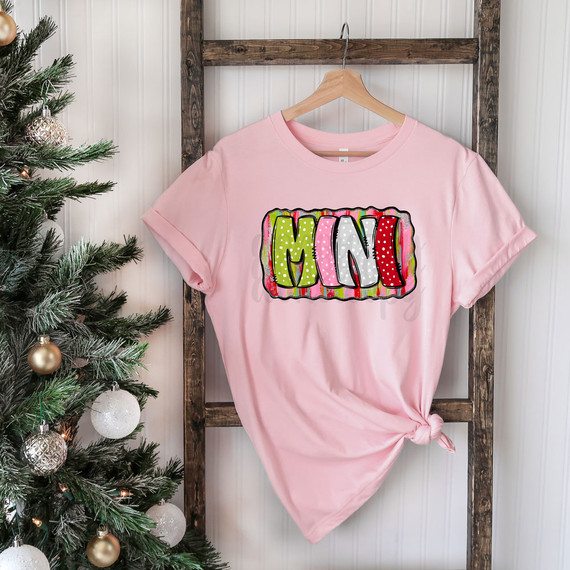 Mini Holiday Brushstrokes DTF Heat Transfer, design on a pink T-shirt with colorful, painted holiday themed lettering.