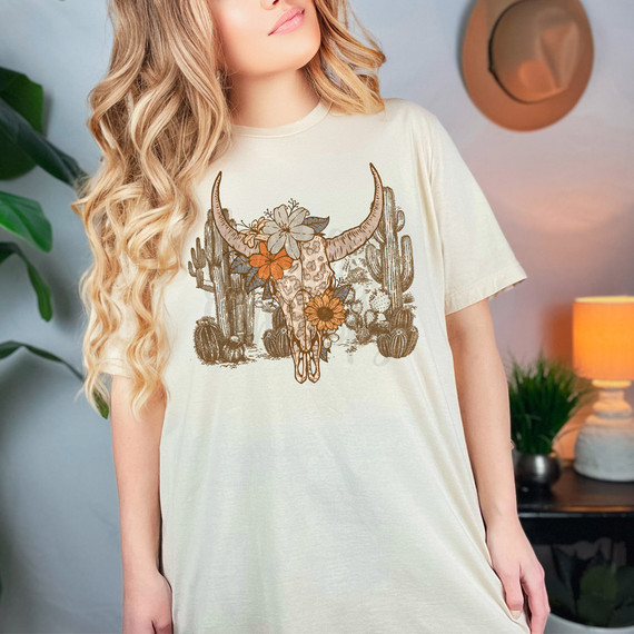 Desert Bull Skull DTF Heat Transfer, product image of a boho style t-shirt featuring a bull skull with desert floral design and cacti in earthy tones.