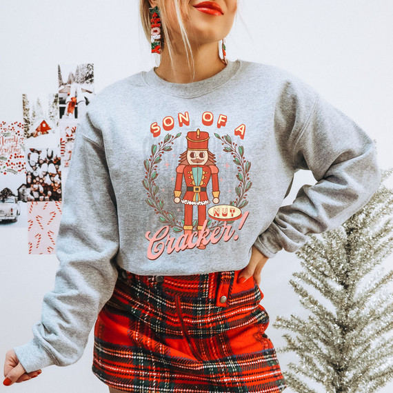 Son Of A Nutcracker Vintage DTF Heat Transfer, festive holiday sweatshirt featuring a nutcracker graphic and Christmas decorations.