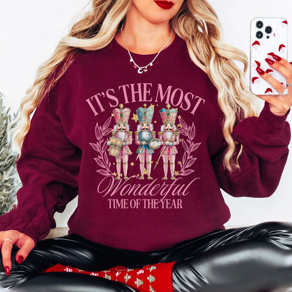 It's The Most Wonderful Time Of The Year Nutcrackers PINK DTF Heat Transfer, pink nutcracker Christmas design on a woman's maroon sweatshirt.