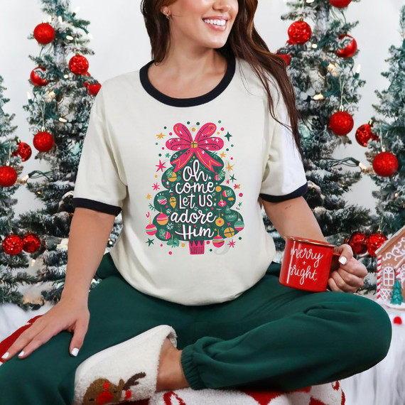 Oh Come Let Us Adore Him Christmas Tree DTF Heat Transfer, Christmas-themed design on a woman wearing a casual t-shirt with Christmas decorations in the background.
