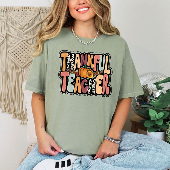 Thankful Teacher DTF Heat Transfer, woman wearing a T-shirt with 'Thankful Teacher' design featuring pumpkin and flower graphics.