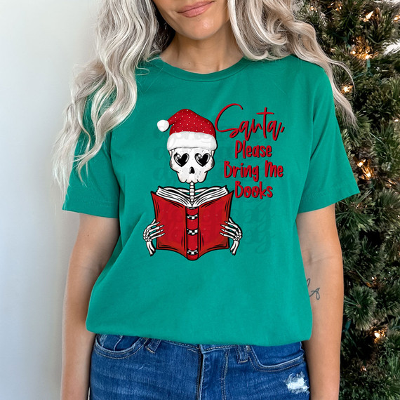 Santa, Please Bring Books DTF Heat Transfer, Christmas-themed graphic T-shirt with a skeleton wearing a Santa hat and holding a book.