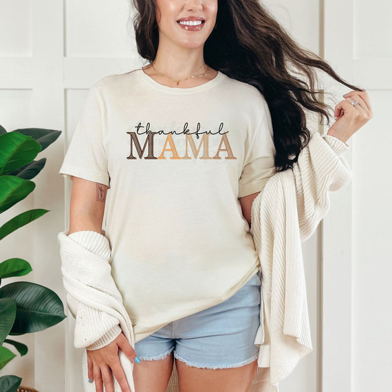 Thankful Mama Fall Monotone DTF Heat Transfer, a woman wearing a T-shirt with the phrase "thankful MAMA" in fall tones, showcasing a product for fall-themed apparel customization.