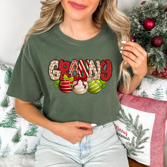 Granny Christmas Bells DTF Heat Transfer, festive Christmas-themed heat transfer design on a woman's t-shirt with holiday ornaments and text.