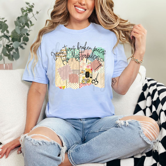 Jesus Turns Broken Pieces Into Masterpieces DTF Heat Transfer, woman wearing a light blue T-shirt with the printed design of this product featuring artistic paper collage, floral patterns, and crafting tools.