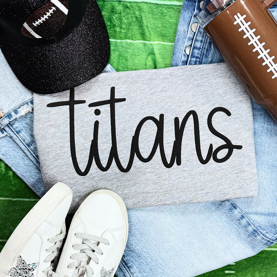 Titans Black PUFF Screen Print Heat Transfer, close-up of a black glittery puff heat transfer design on a T-shirt with sneakers, denim, and accessories around.