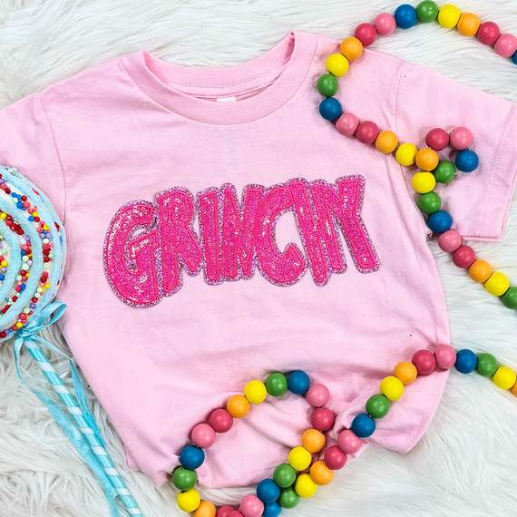 YOUTH Grinchy Pink Sequin Patch, a pink T-shirt with the word 'GRINCHY' in large pink glittery lettering.