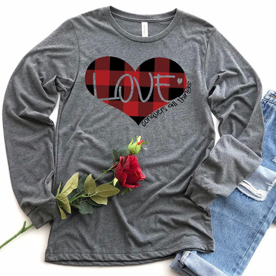 Love Conquers All Things Screen Print Heat Transfer on a gray long sleeve shirt, featuring a red and black plaid heart with the word 'LOVE' and the phrase 'conquers all things' underneath.