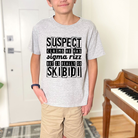 Suspect Claims He Has Sigma Rizz But Is Really So Skibidi DTF Heat Transfer, a gray t-shirt worn by a young boy with bold black text design.