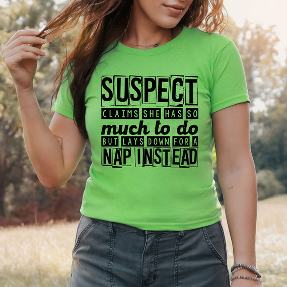 Suspect Claims She Has So Much To Do But Lays Down For A Nap Instead DTF Heat Transfer, woman wearing a bright green T-shirt with humorous text outdoors on a sunny day