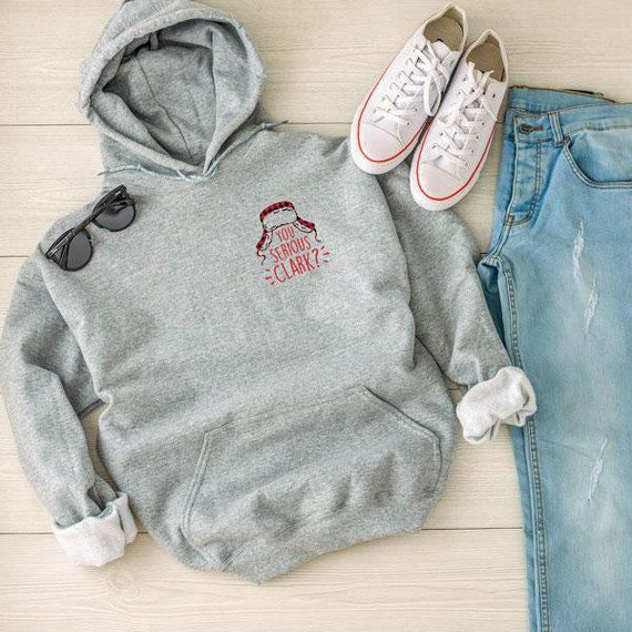 You Serious Clark POCKET/CAN HUGGER Screen Print Heat Transfer, casual clothing and accessories including a gray hoodie with logo, white sneakers, jeans, sunglasses, and a white sock laid on a wooden surface.