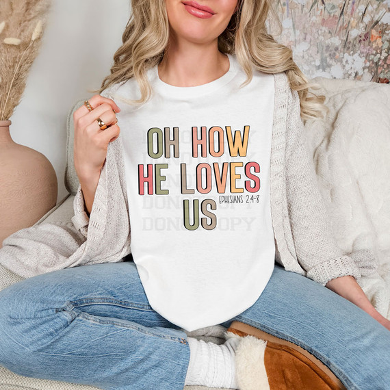 Oh How He Loves Us Boho DTF Heat Transfer, a woman wearing a white T-shirt with colorful text featuring the Bible verse Ephesians 2:4-8.