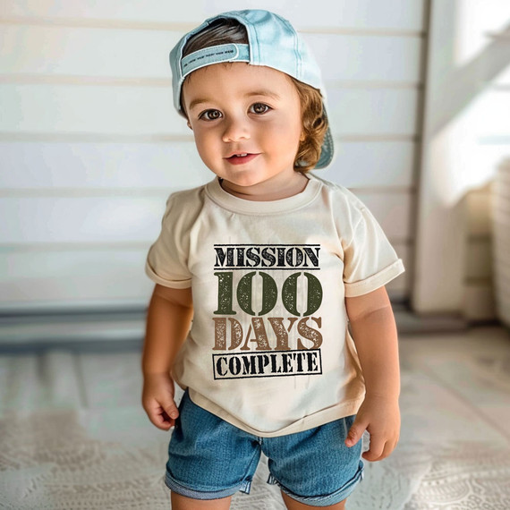 Mission 100 Days Complete DTF Heat Transfer - Young boy wearing a T-shirt with the text 'MISSION 100 DAYS COMPLETE' printed on it.