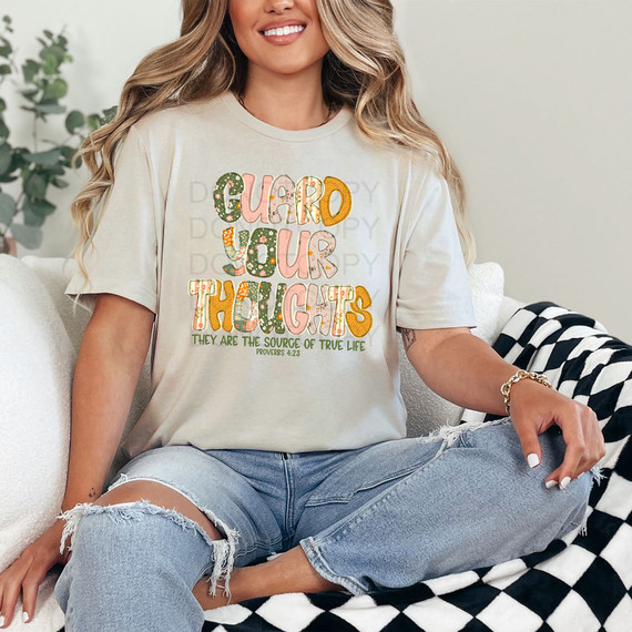 Guard Your Thoughts They Are The Source Of True Life GREEN DTF Heat Transfer, colorful and decorative text design on a woman's T-shirt.