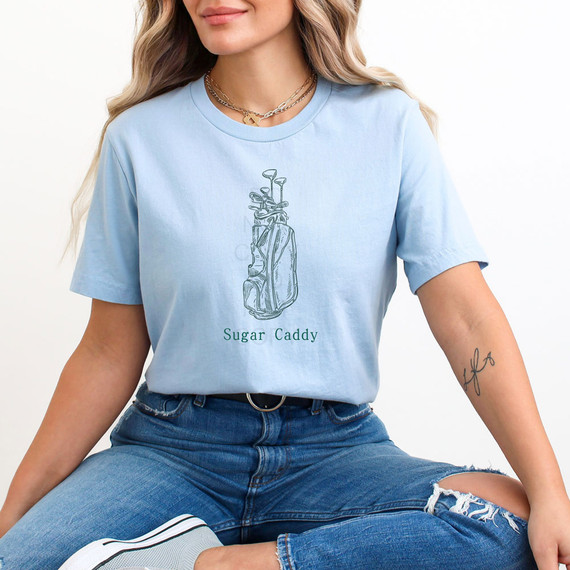 Sugar Caddy DTF Heat Transfer, a design of a golf bag with golf clubs on a woman's light blue T-shirt.