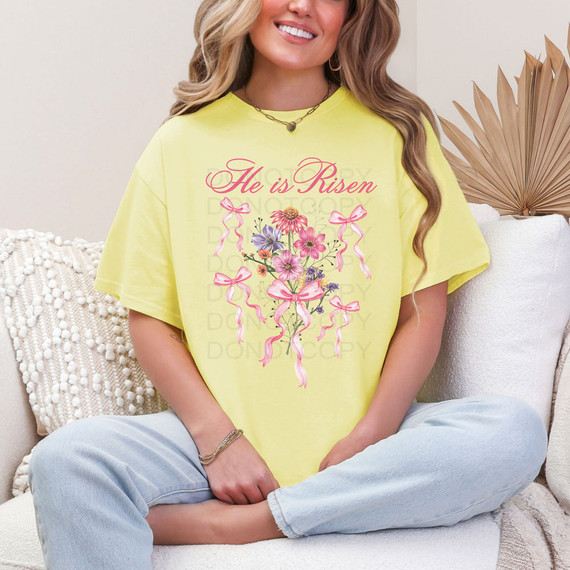 He Is Risen Coquette Bows DTF Heat Transfer, a yellow T-shirt with pink floral design and bows, printed with the phrase "He is Risen."