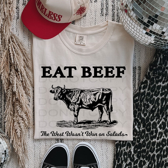 Eat Beef The West Wasn't Won On Salads DTF Heat Transfer T-shirt, a white T-shirt with a black cow graphic and bold text.