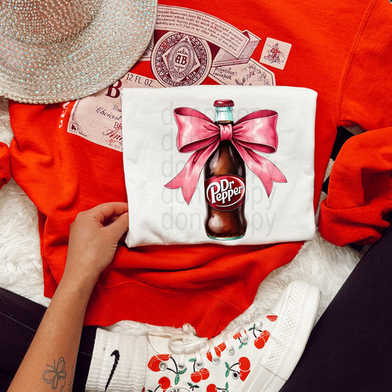 DrP Coquette DTF Heat Transfer, vibrant printed design of a bottle of Dr. Pepper with a pink bow on a white fabric.