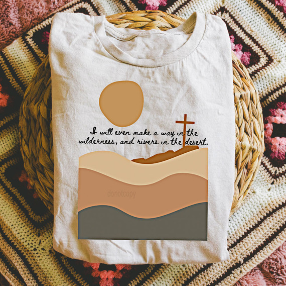 I Will Even Make A Way In The Wilderness, And Rivers In The Desert DTF Heat Transfer, T-shirt with desert landscape design including a sun, hills, and a cross, featuring a biblical quote.