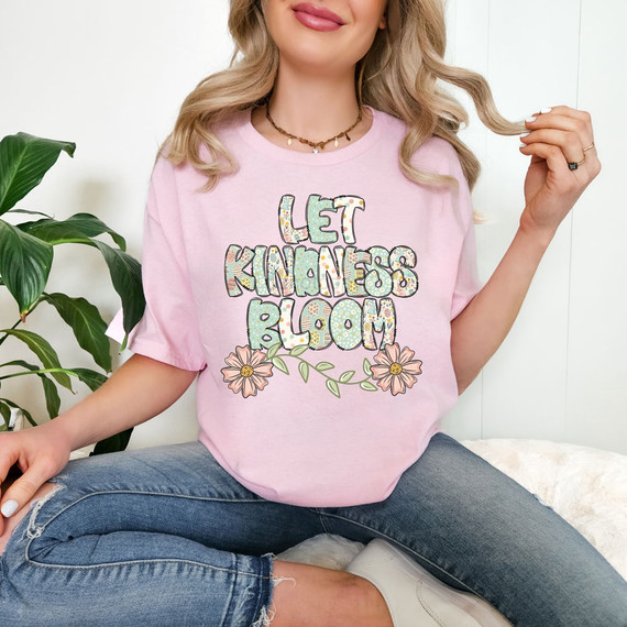 Let Kindness Bloom Easter Pattern DTF Heat Transfer, colorful floral design and text on a pink T-shirt worn by a woman.