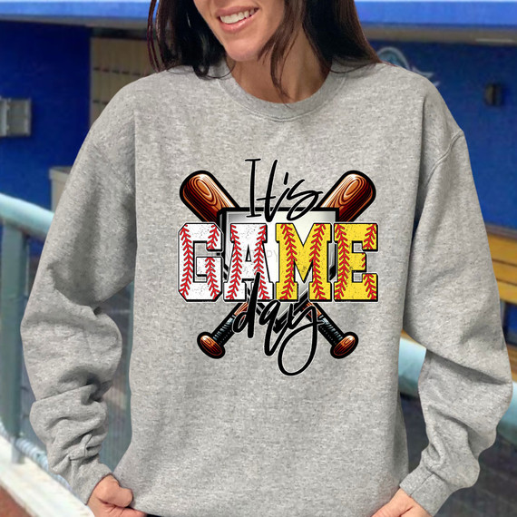 It's Game Day Baseball/Softball DTF Heat Transfer, a colorful graphic design on a gray sweatshirt featuring baseball bats and the words 'It's Game Day'.