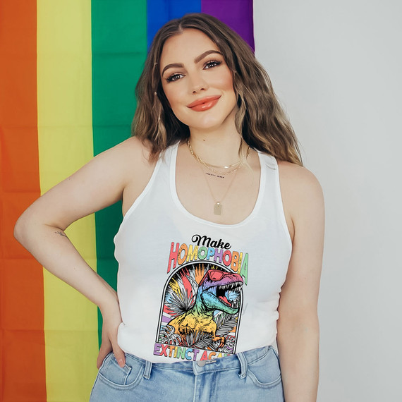 Make Homophobia Extinct Again DTF Heat Transfer, colorful dinosaur design on white tank top with rainbow pride flag in background.