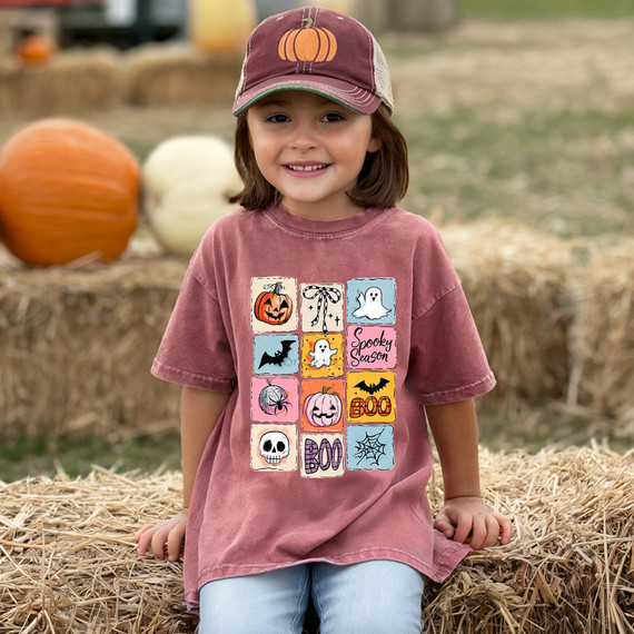 Cute Halloween Color Block DTF Heat Transfer, a colorful patchwork design featuring pumpkins, ghosts, bats, spiders, skulls, web, and Halloween phrases on a child's t-shirt for festive seasonal apparel.