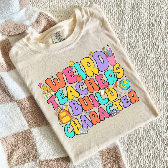 Weird Teachers Build Character DTF Heat Transfer, colorful graphic design on a white T-shirt showing school-themed illustrations and text.