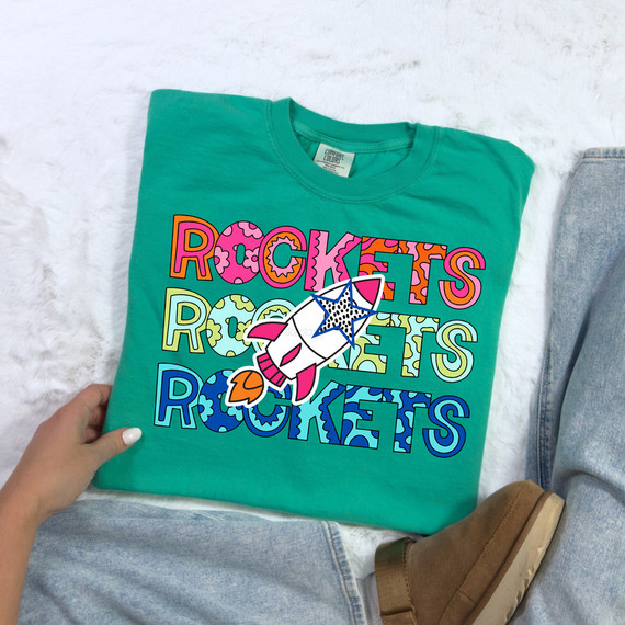 Rockets Stacked Pattern DTF Heat Transfer, colorful rocket and pattern design on teal T-shirt.