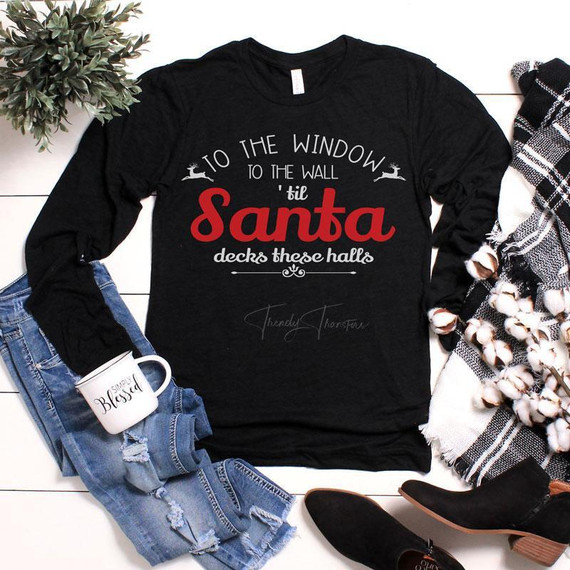 From The Window To The Wall Till' Santa Decks These Halls Screen Print Transfer, black sweatshirt with festive holiday text and reindeer graphics.