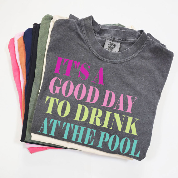 It's A Good Day To Drink At The Pool DTF Heat Transfer, folded grey T-shirt with colorful text design for pool or summer themed apparel.
