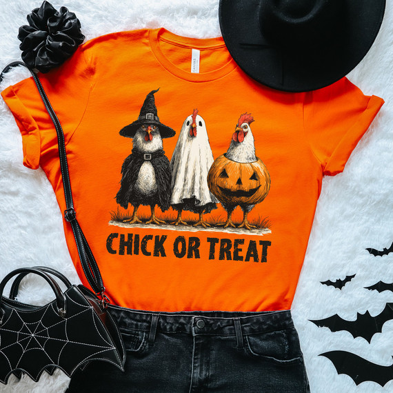 Chick Or Treat Halloween DTF Heat Transfer, orange t-shirt with chick characters dressed in a witch, ghost, and pumpkin costume. The shirt features Halloween-themed illustrations and text.