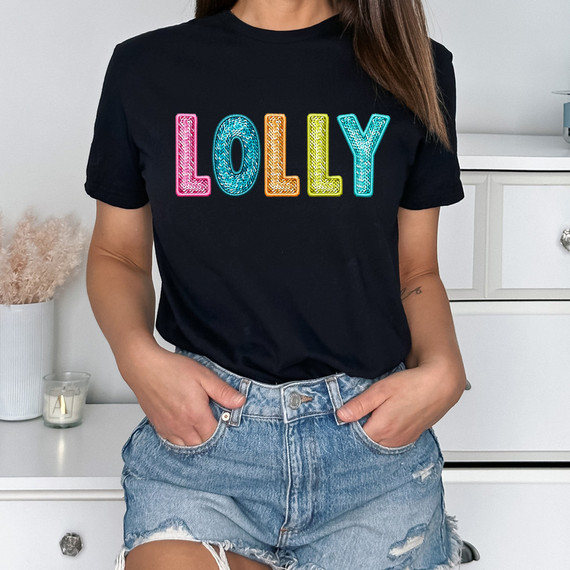 Bright Groovy Lolly Faux Sequins DTF Heat Transfer, colorful sequin-embellished lettering on a black T-shirt.
