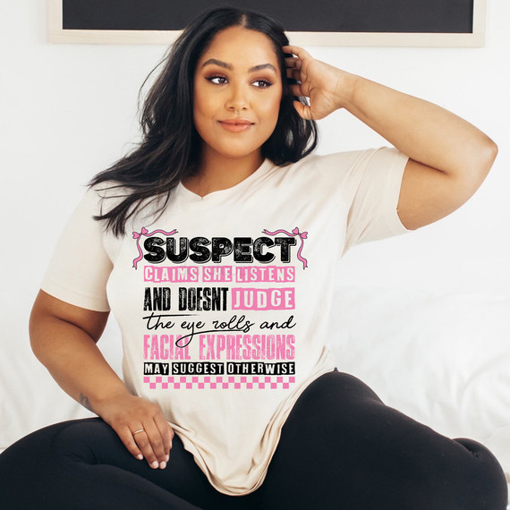 Suspect Claims She Listens And Doesn't Judge, DTF Heat Transfer, women's T-shirt with humorous text and eye roll and facial expression graphics.
