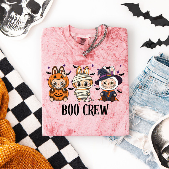 Boo Crew Labubu DTF Heat Transfer, Halloween-themed graphic design on a pink t-shirt featuring cute cartoon characters dressed as a pumpkin, mummy, and witch surrounded by bats.