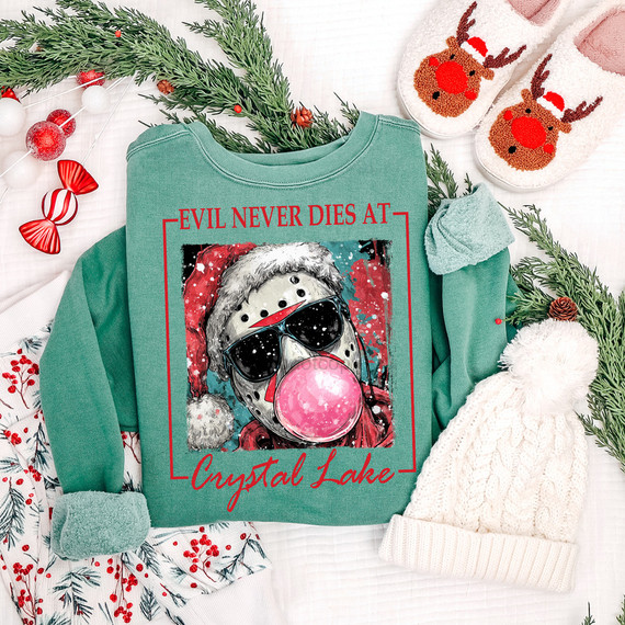 Evil Never Dies DTF Heat Transfer, graphic image of a hockey mask wearing dog with sunglasses and a Santa hat, on a green sweatshirt surrounded by Christmas decorations.