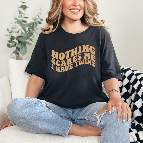 Nothing Scares Me I Have Twins DTF Heat Transfer, woman wearing a black t-shirt with the text 'Nothing Scares Me I Have Twins' printed in tan color.