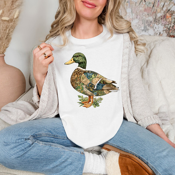 Patchwork Duck DTF Heat Transfer, creative patchwork duck design on a white T-shirt worn by a woman sitting on a sofa.