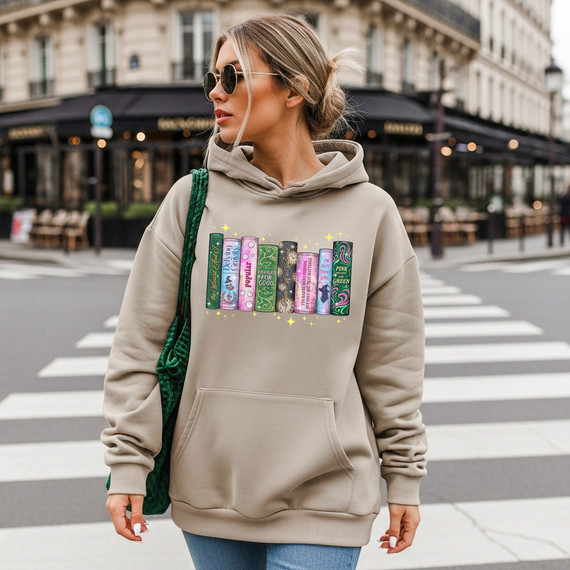 Wicked Books DTF Heat Transfer, graphic design of colorful books printed on a beige hoodie worn by a woman crossing a city street.