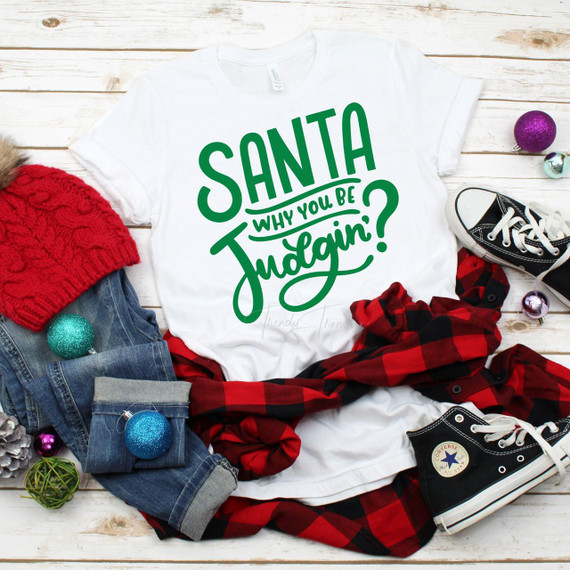 Santa Why you be judgin? Sublimation Transfer T-shirt with Christmas themed clothing and decorations around it.