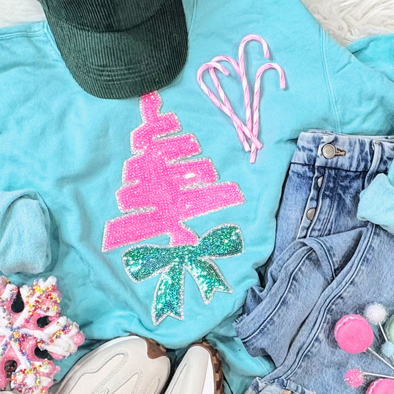 Christmas Scribble Tree Sequin Patch, pink and green sequined Christmas tree patch on a light blue shirt with holiday accessories.