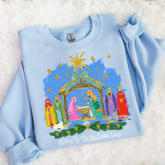 Glory To The Newborn King Nativity DTF Heat Transfer, a festive blue sweatshirt featuring a colorful nativity scene with baby Jesus, Mary, Joseph, the Three Wise Men, animals, and a star, perfect for Christmas celebrations.