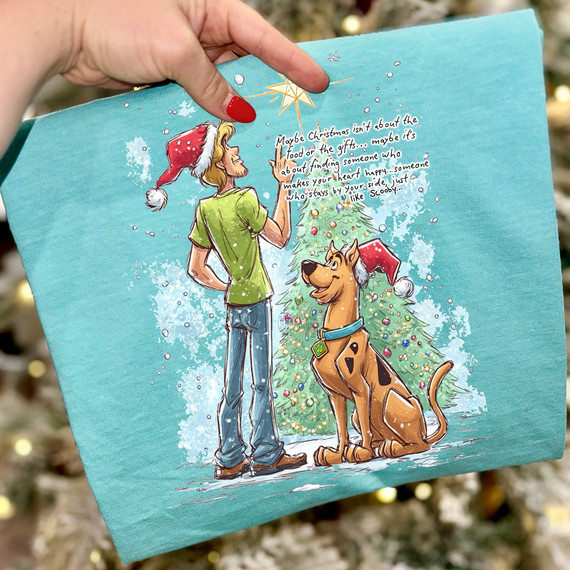 Product Christmas Scene Shag + Dog DTF Heat Transfer, festive holiday illustration of a woman and a dog near a decorated Christmas tree, with a humorous quote about finding happiness during Christmas.