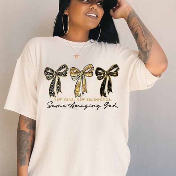 New Year. New Beginnings. Same Amazing God. BLACK DTF Heat Transfer, featuring a woman wearing a white t-shirt with decorated bows and inspirational text.